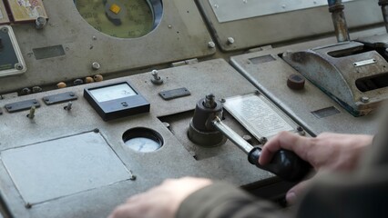 Operator controlling machinery on vintage industrial panel. Clip