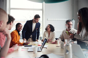 Male and female entrepreneurs planning marketing strategies in office team meeting