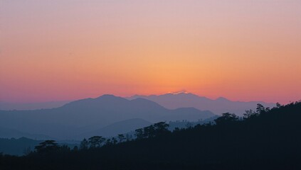 Obraz premium As dusk falls over the mountain range, the landscape is bathed in a stunning, colorful glow.