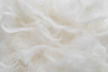 Closeup woolen fiber in neutral white color as background. Natural material texture.