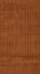 Fototapeta premium Close-up of brown corduroy fabric with vertical ridges, creating a textured surface, suggesting warmth, vintage style, and tactile experience
