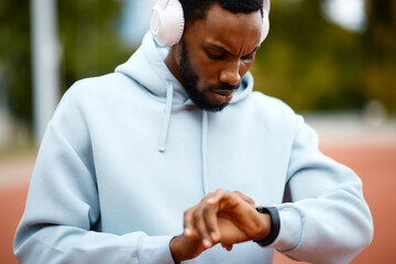 African american man checking fitness tracker during training