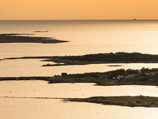 Drone view of island amidst sea at sunrise