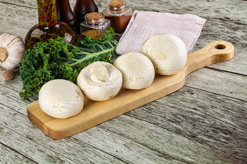 White champignon mushrooms heap over board © Andrei Starostin