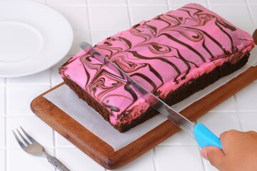 Chocolate brownies square slices served on ceramic plate with crumbs.