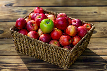 Fresh red apples in basket on wooden table. Juicy organic apples harvested from farm. Autumn season fruit. Ripe organic apple. Harvest with fresh red apples. Basket full of fresh apples.