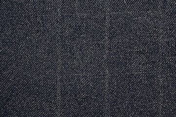 Detailed macro shot of gray denim textile surface with diagonal weave pattern. Fabric suitable for clothing, upholstery, and decorative purposes.
