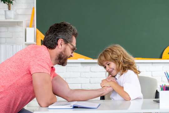 School kid and teacher learning study in class. Pupil of primary elementary school has lesson. Kid boy with teacher learn english language or mathematics.