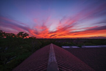 Obraz premium Scarlet evening sky above the rooftop