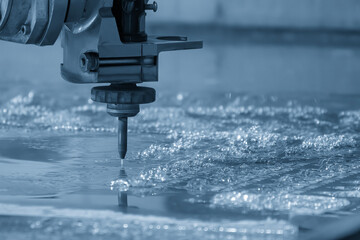 Close-up scene of multi-axis abrasive waterjet cutting machine cut the aluminum plate in the light...