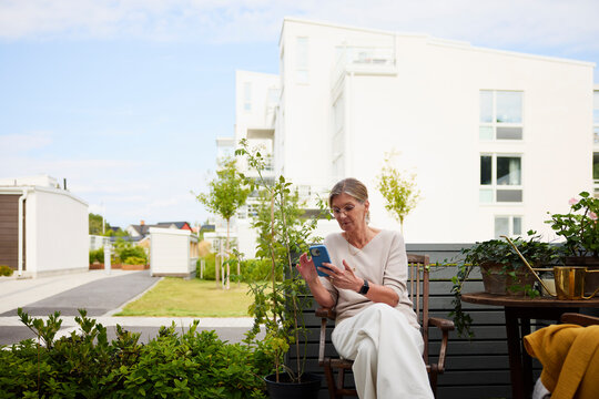 Senior woman spending leisure time scrolling social on smart phone