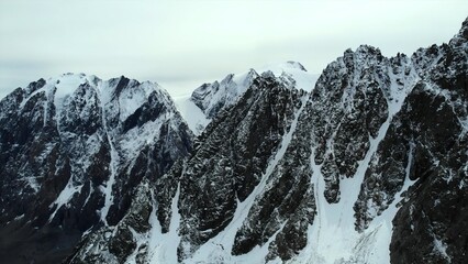 Snowy mountain peaks under a cloudy sky. Media
