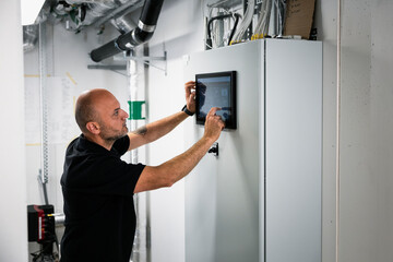 Focused engineer using digital tablet at factory