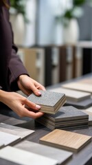 A woman with long dark hair examines various samples of flooring materials in a modern interior design showroom. The scene emphasizes the concept of home renovation.