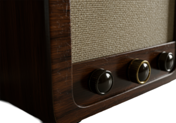 Extreme close-up of vintage 1950s dark brown wooden tube radio, showing palpable wood grain, light beige fabric grille, gold-rimmed knob, amber glow. Nostalgic craftsmanship concept