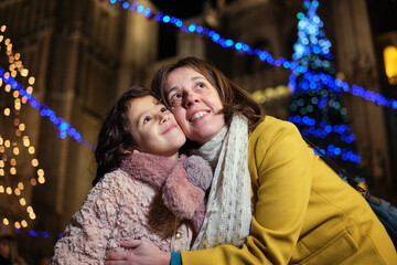 Mother and daughter at Christmas market pointing at candy apple