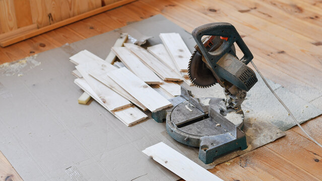 Miter Saw and Cut Lumber on Wooden Floor – DIY Carpentry Project in Progress