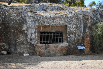 Photo shows the entrance to a twin funerary monument, carved into the natural rock at the Filopappou hill next to the Acropolis of Athens.
