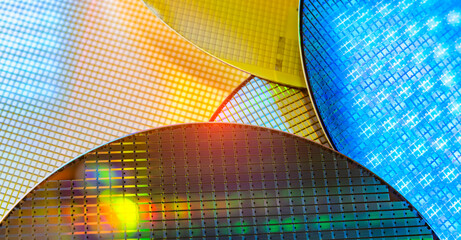 Silicon Wafers with microchips reflecting different colors.used in electronics for the fabrication of integrated circuits