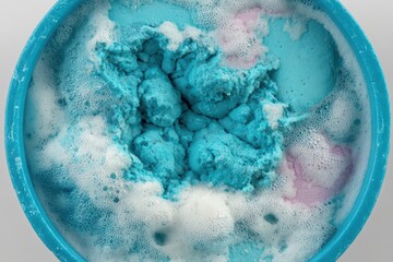 Fototapeta premium Unique bath salt mixture in a vibrant blue bowl with bubbly foam emerging and a touch of pink, creating a relaxing and visually appealing bathing experience captured with clarity