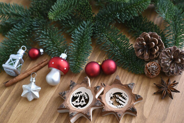 Preparing christmas decoration with red silver and wooden ornaments with fir branches on wooden background