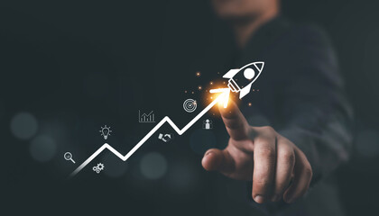 Businessman pointing at rocket icon launching upward on growth chart, symbolizing business success, startup innovation, financial growth, digital strategy, and achievement in modern technology.