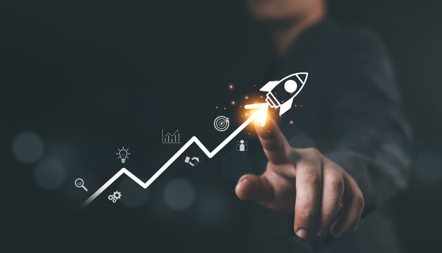Businessman pointing at rocket icon launching upward on growth chart, symbolizing business success, startup innovation, financial growth, digital strategy, and achievement in modern technology.