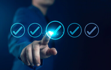Businessman touching glowing digital check mark icon on virtual screen, representing task completion, success, quality assurance, productivity, and efficiency in modern business technology.