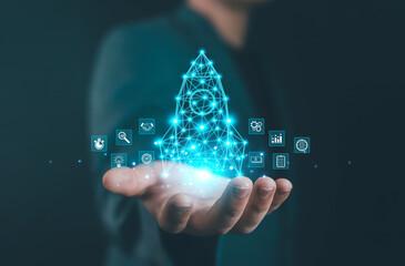 Businessman holding glowing digital rocket made of connected network lines with business icons, symbolizing startup growth, innovation, technology, entrepreneurship, and successful transformation.