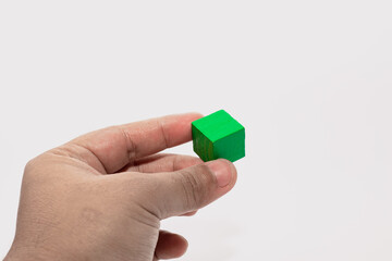 Hand Holding Green Wooden Block