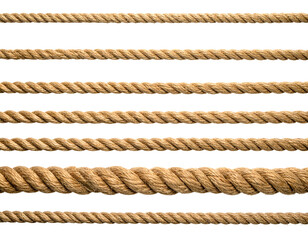 Close-up of various thick, natural ropes against a solid black background