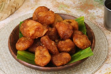 Indonesian fried cassava snack Getuk Goreng, sweet and crispy, served on banana leaf and wooden plate.