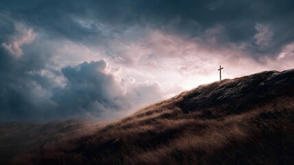 Fototapeta premium A solitary cross stands silhouetted atop a windswept hill under a dramatic light filled cloudy sky