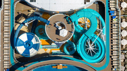 Aerial perpendicular view of colorful water slides located on the top deck of a cruise ship.
