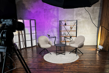 Podcast setup with microphones and cozy seating area in a stylish studio