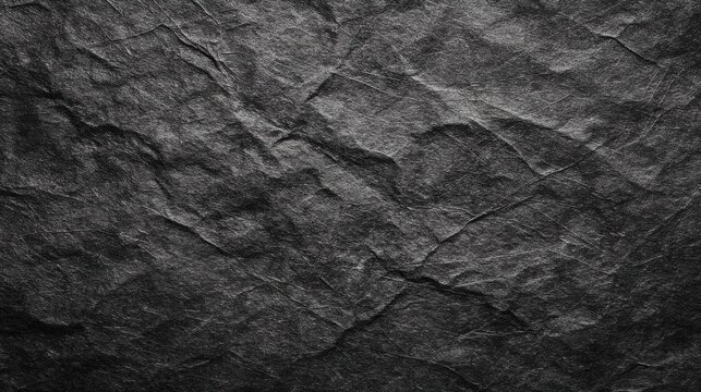 A dark textured background of crumpled black paper creating an abstract and rugged surface with many folds and creases - Powered by Adobe