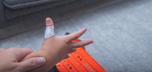 The child has a cut wound covered with a bandage