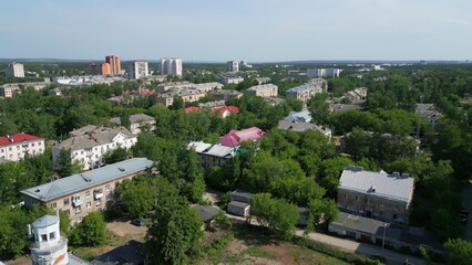 Obraz premium Aerial view panning over a residential district with colorful rooftops and green trees. Clip