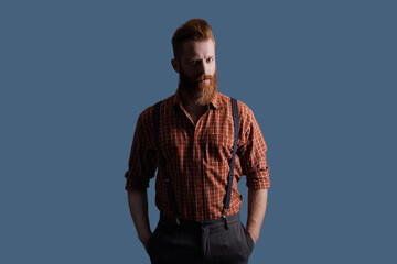 Fototapeta premium Redhead man with hairstyle. Retro male fashion style. Male vintage style. Vintage guy in retro suspenders. Brutal elegant man with red beard. Retro man in suspenders isolated on grey