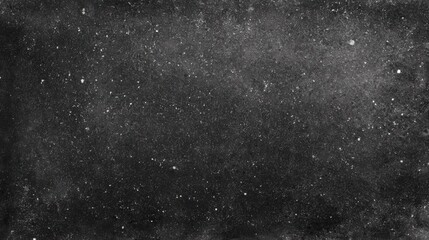 A dark textured surface covered in white specks and dust creating an abstract background similar to a night sky
