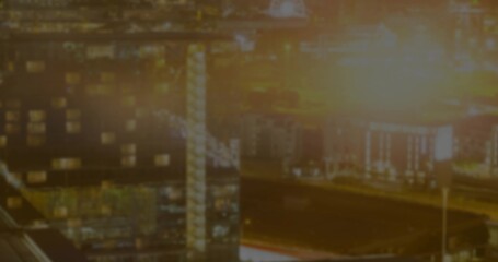 Glowing port warehouses with lattice tower casting light at night, with floodlights, loading docks