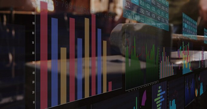 Displaying colorful bar graph with green line on computer monitors at trading desk, with keyboard