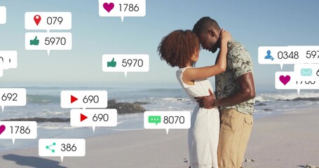 Embracing couple in sundress, tropical shirt touching foreheads on shore, with social icons