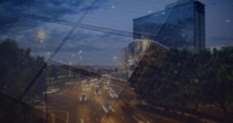 Projecting grid panels overlaying nighttime street, with light trails, trees and glass building