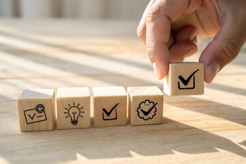 Hand placing a wooden block with a checkmark symbol to complete a task list