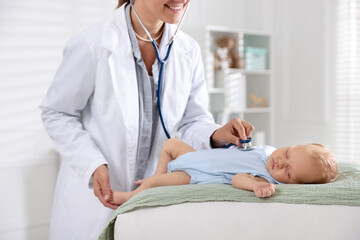 Obraz premium Doctor examining cute little child with stethoscope in hospital, closeup. Checking baby's health