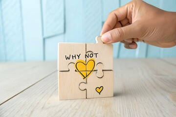 Hand placing last puzzle piece with heart and why not message