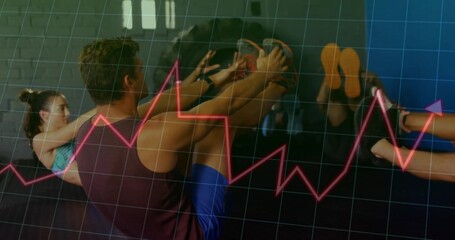 Balancing man wearing burgundy tank top holding V-sit on exercise mats in gym, with data overlay