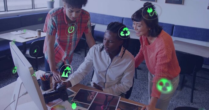 Collaborating professionals pointing and discussing printed photos at coworking desk, DSLR camera