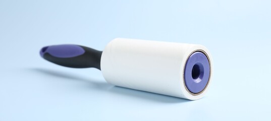 One lint roller on light blue background, closeup